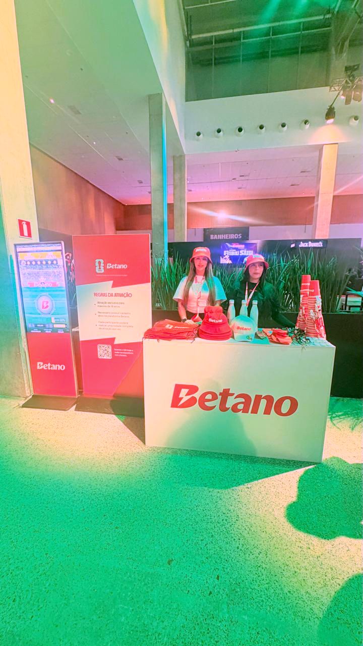 Totem digital ao lado de estande de ativação de marca em feira